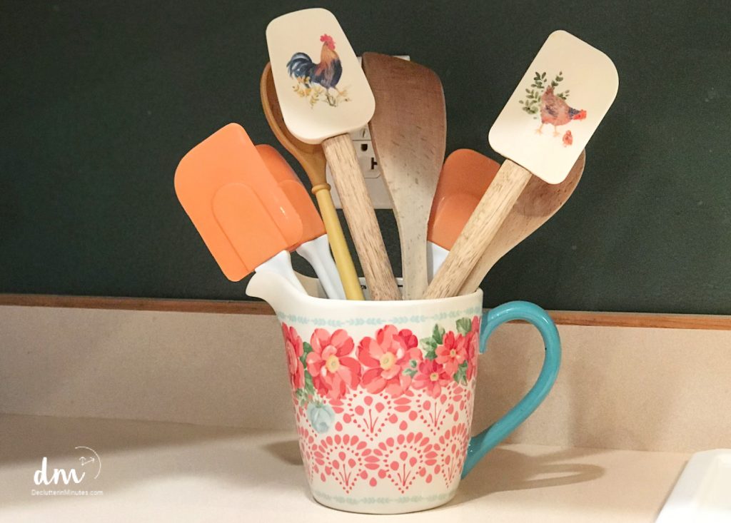 a ceramic crock fill with kitchen utensils