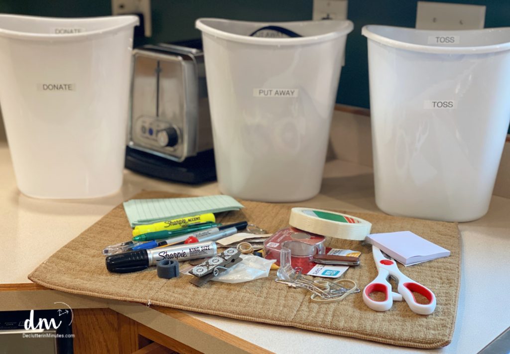 a towel on a counter with clutter on it and 3 white cans in the background