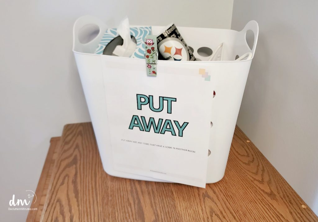 white clothes basket full of stuff with a label that says Put Away