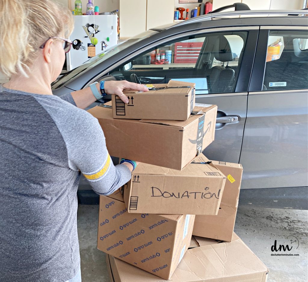 a woman taking donation boxes out to her car 