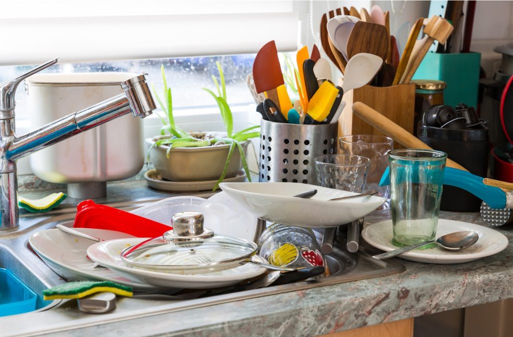 dirty dishes on a counter and in a kitchen sink copy