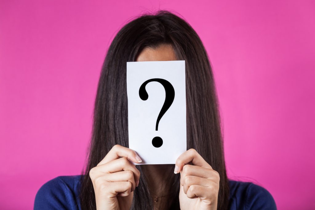 Woman Hiding Face Behind a Question Mark