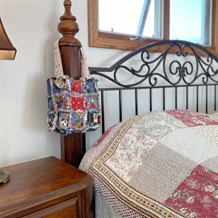 a bag hanging on the side of a headboard in a bedroom