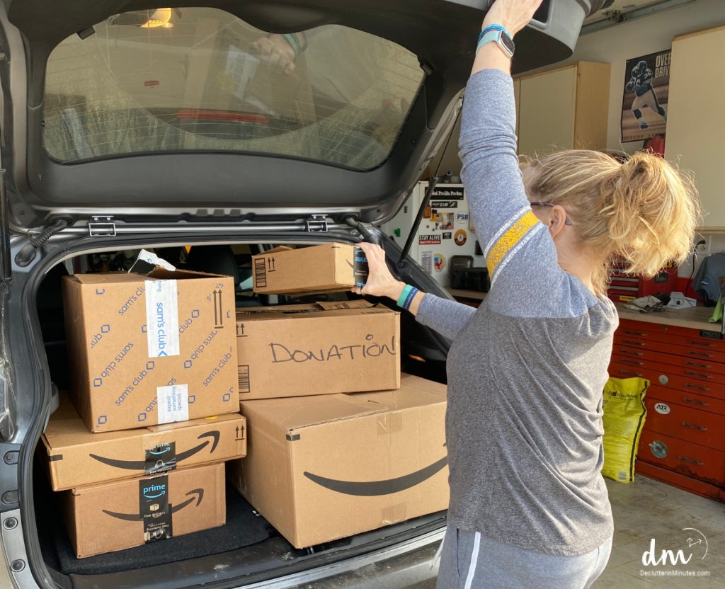 woman putting boxes of donations into the back of her car