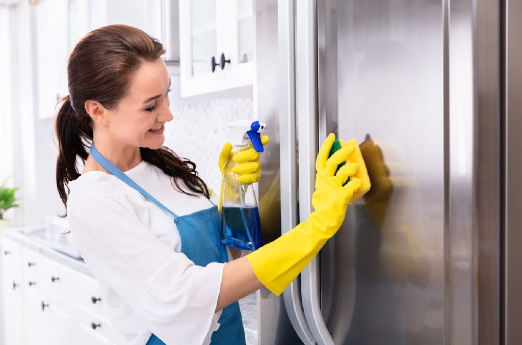 cleaning the outside of a kitchen refrigerator copy