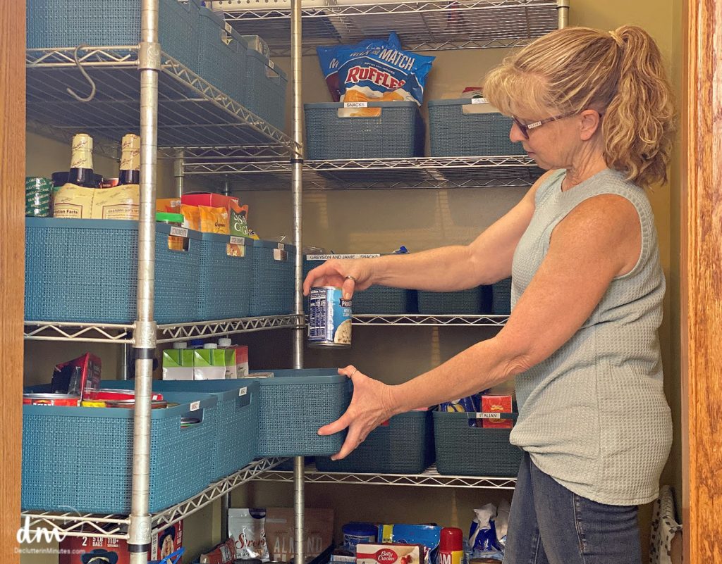 woman putting cans in a basket in a pantry copy