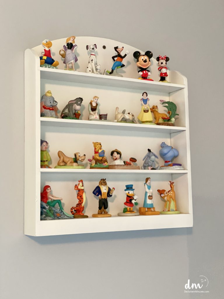 collection of Disney figurines on a white shelf in a bedroom