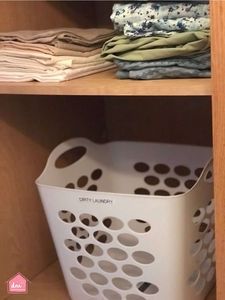 a laundry bin in a linen closet