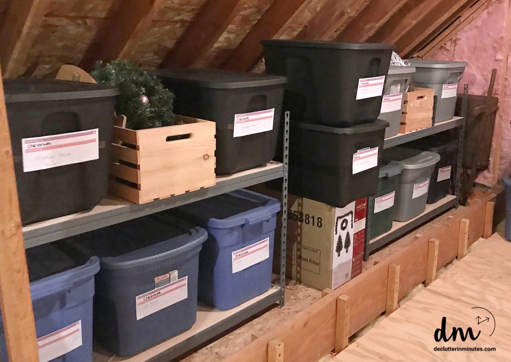 plastic storage bins and wooden crates labeled and neatly organized on shelves in an attic space
