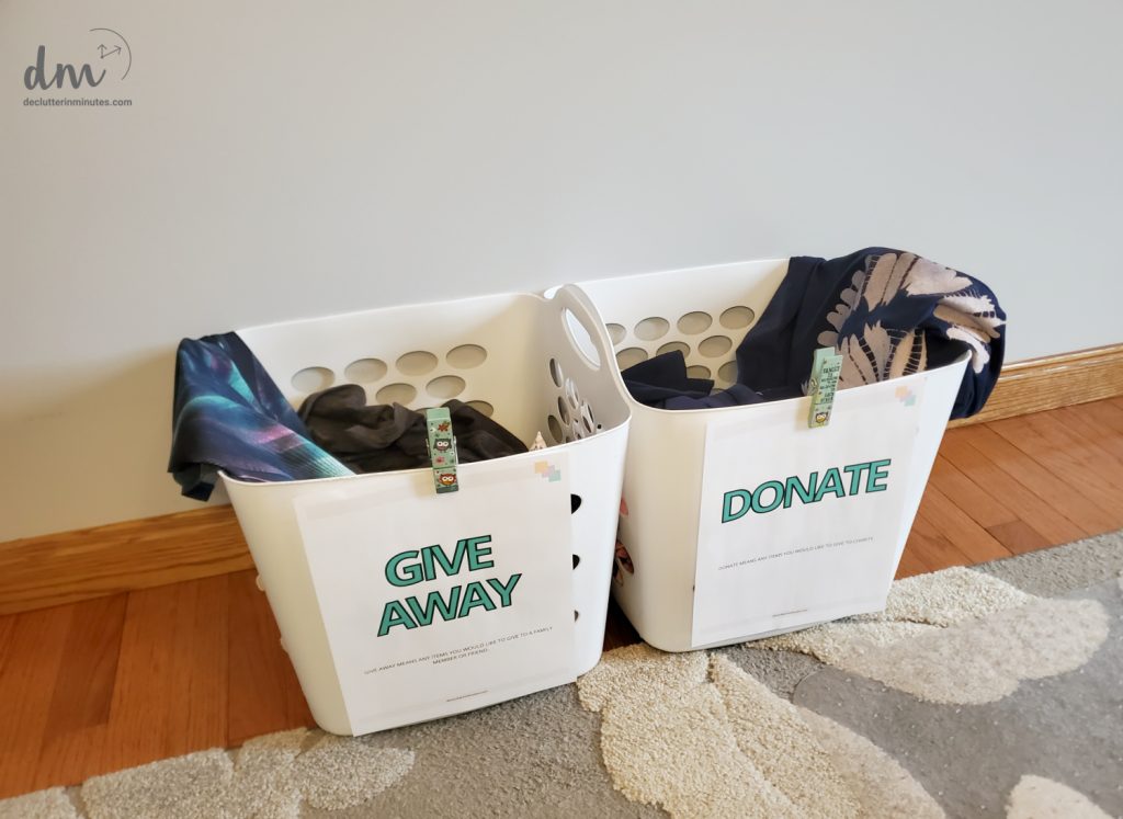 two white baskets labled donate and give away filled with clothes