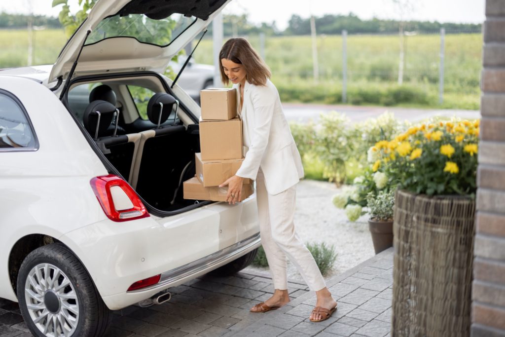 woman putting donations into the back of her car
