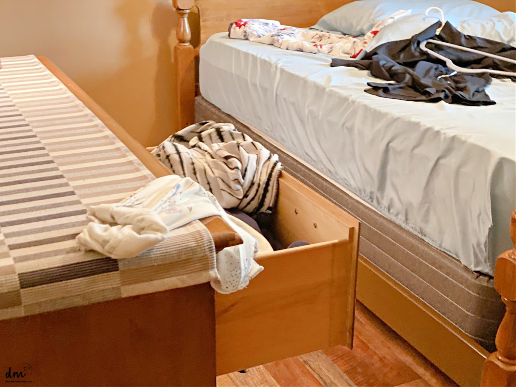a messy bedroom with clothes lying out