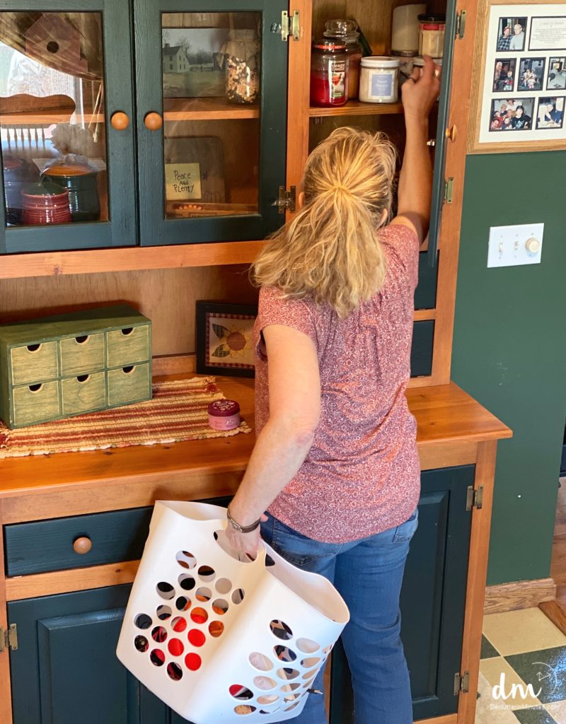 putting things away into a cabinet from a white basket copy