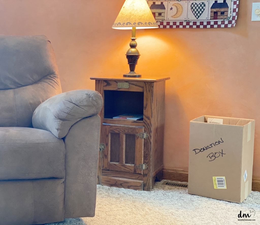 a brown box labeled donation sitting next to a table in a family room