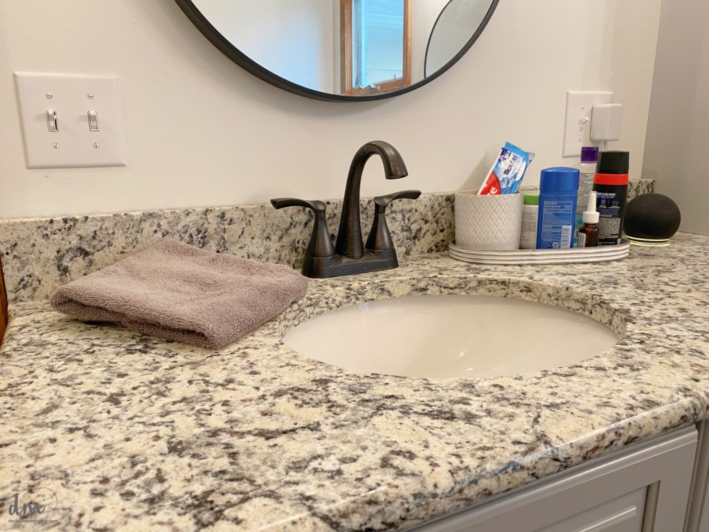 a neat and organized grey bathroom sink area