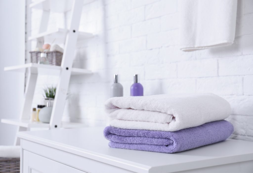 A white and purple towel sitting in a bathroom on a vanity counter