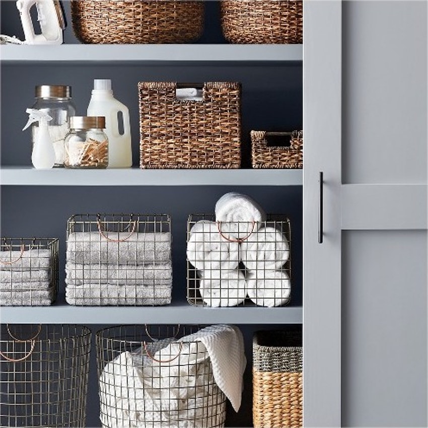 linen closet with baskets of towels and bathroom supplies
