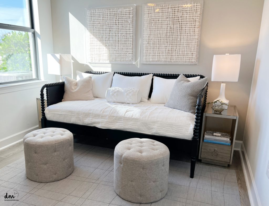 a day bed with two round stools and a bedside table