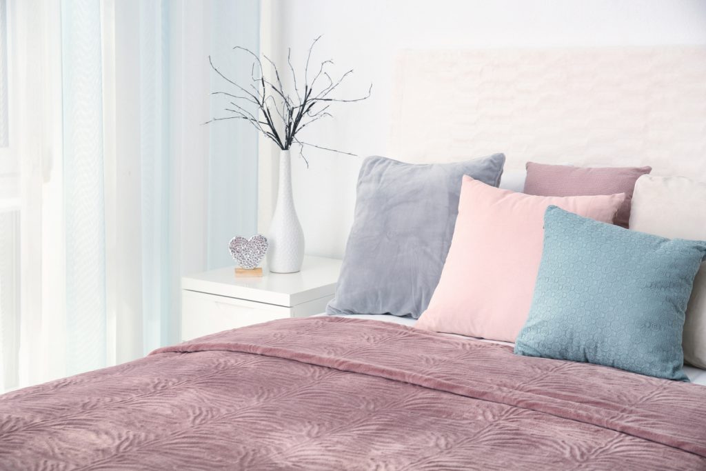 bed with pastel covered pillows