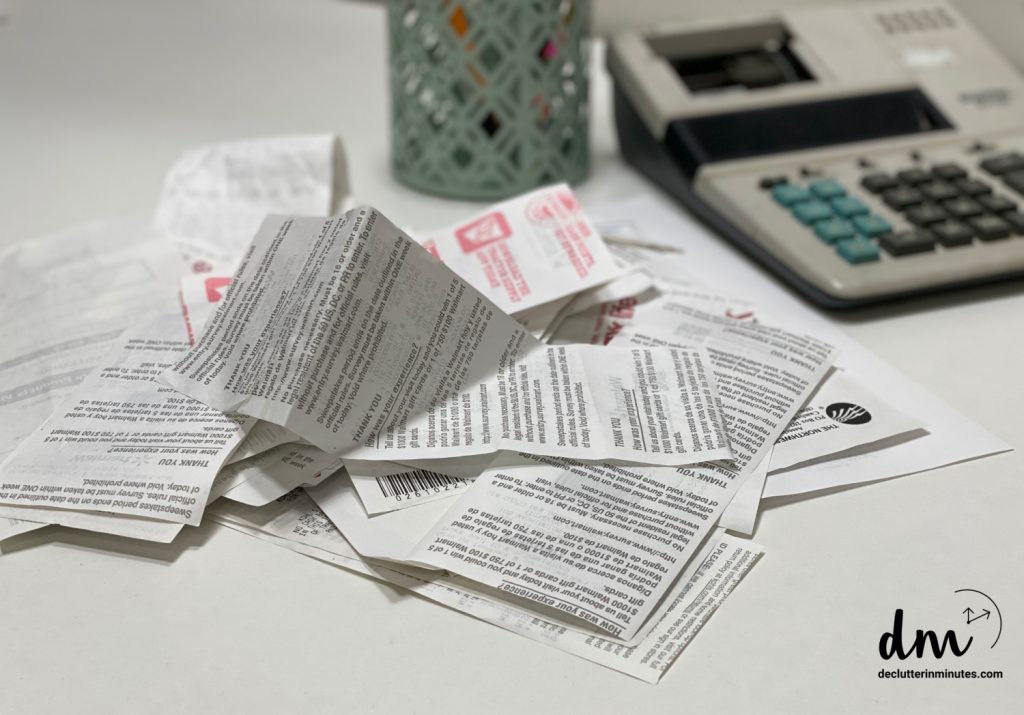a pile of receipts near to a calculator on a desk