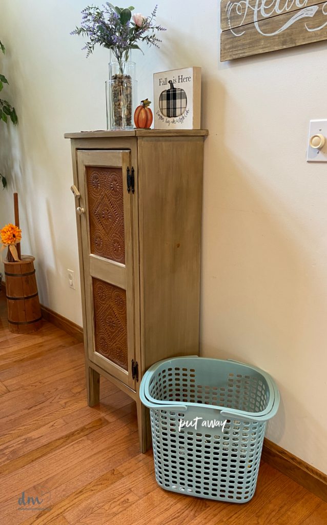 a teal basket labeled put away in a room 