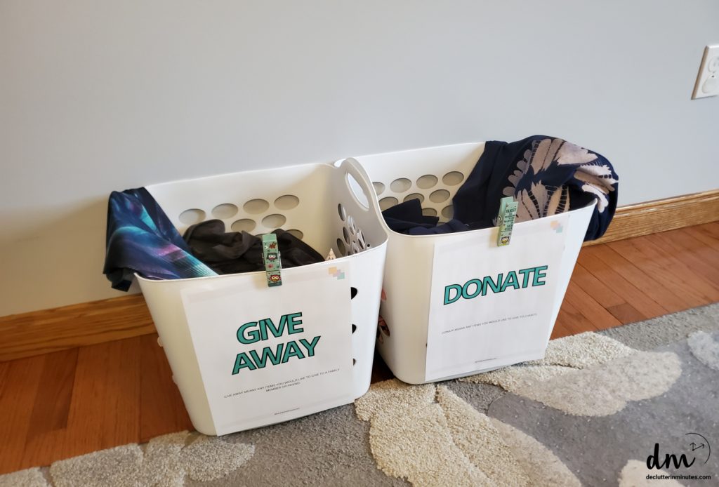 two white baskets labeled give away and donate with clothes inside