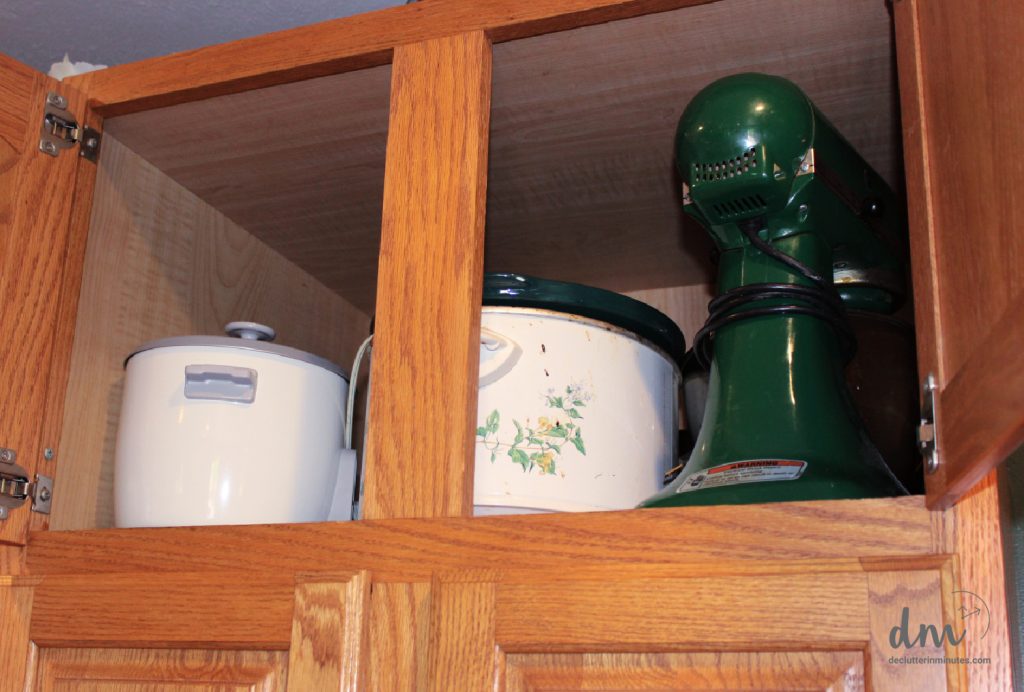 3 small appliances in an upper cabinet of a kitchen