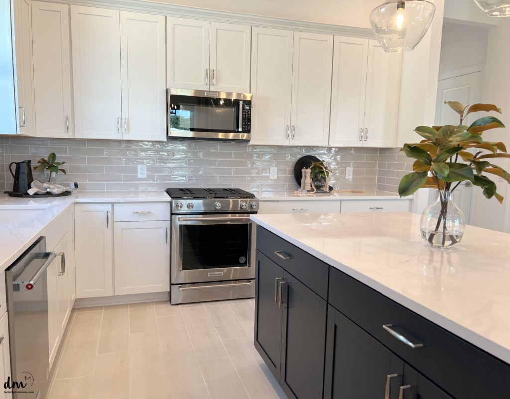 a new kitchen with white cabinets and steel appliances