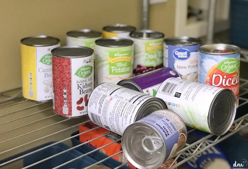 fallen cans on a wire rack pantry shelf