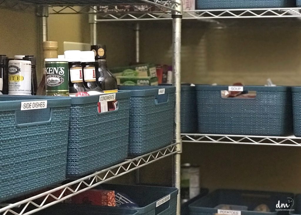 A pantry with labeled blue storage bins for condiments, side dishes, soup, and other essentials