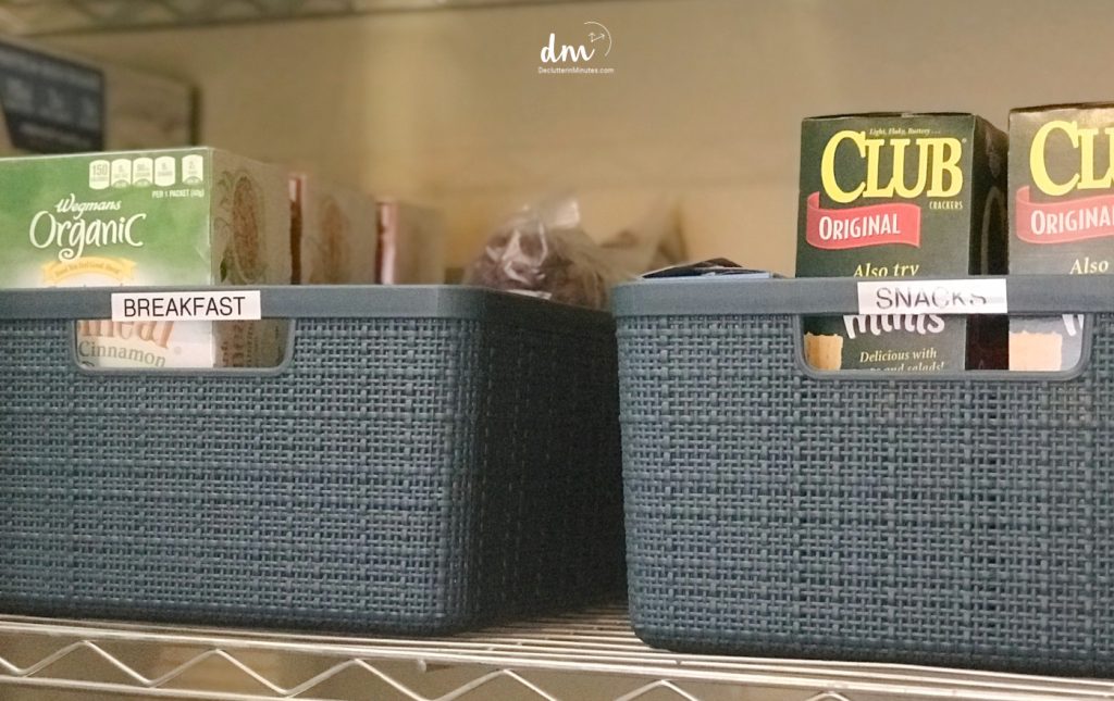 two blue baskets in a pantry filled with snacks