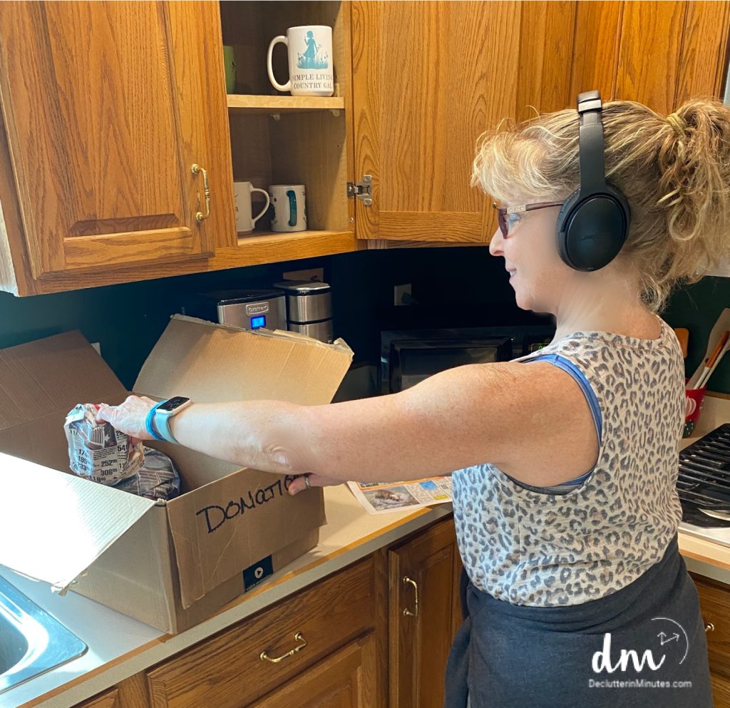 woman cleaning a kitchen with headphones on