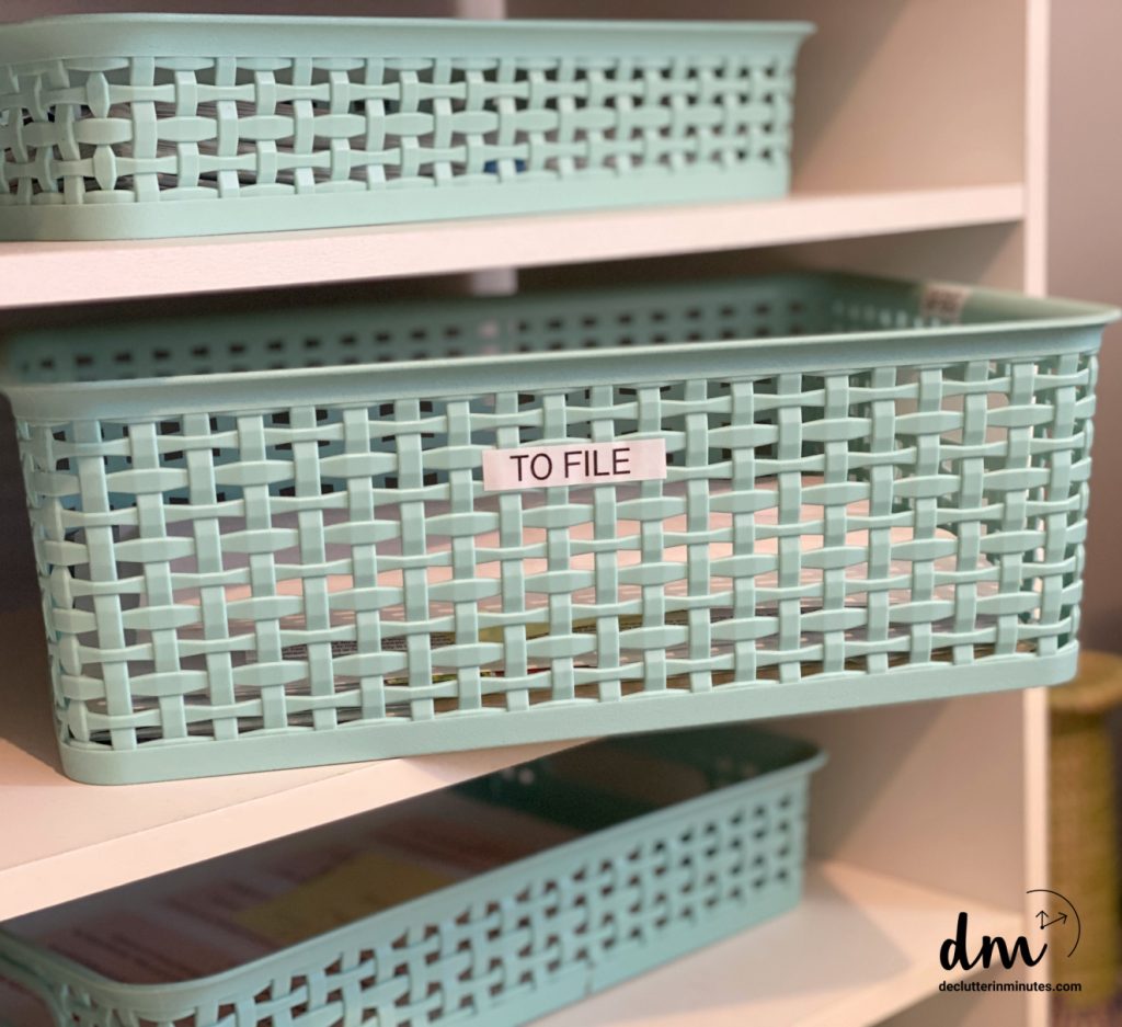 A green BASKET LABELED TO FILE ON A SHELF
