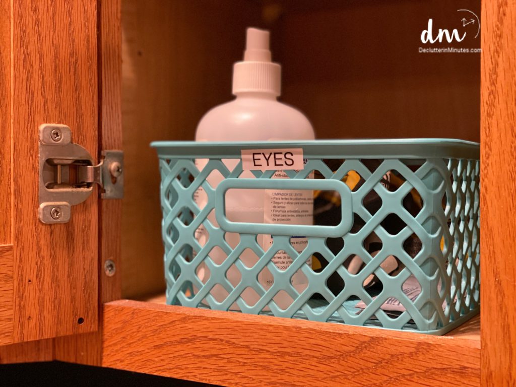 a blue basket labeled eyes in a cabinet