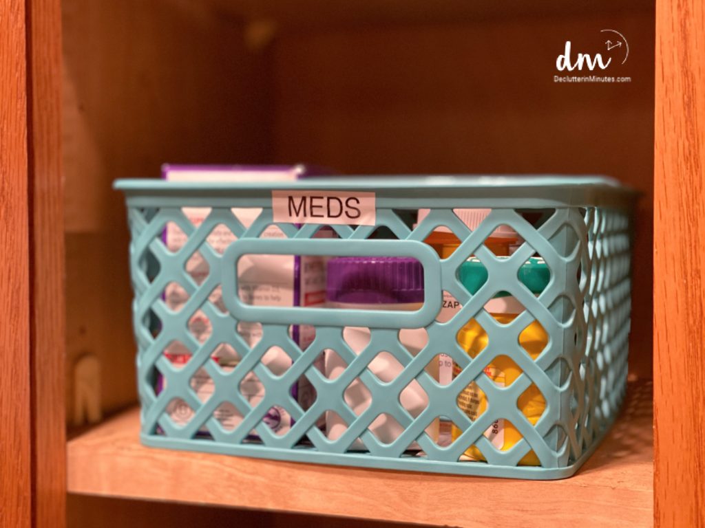a blue basket labeled meds in a cabinet