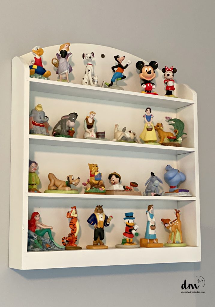 a collection of Disney figurines on a white shelf