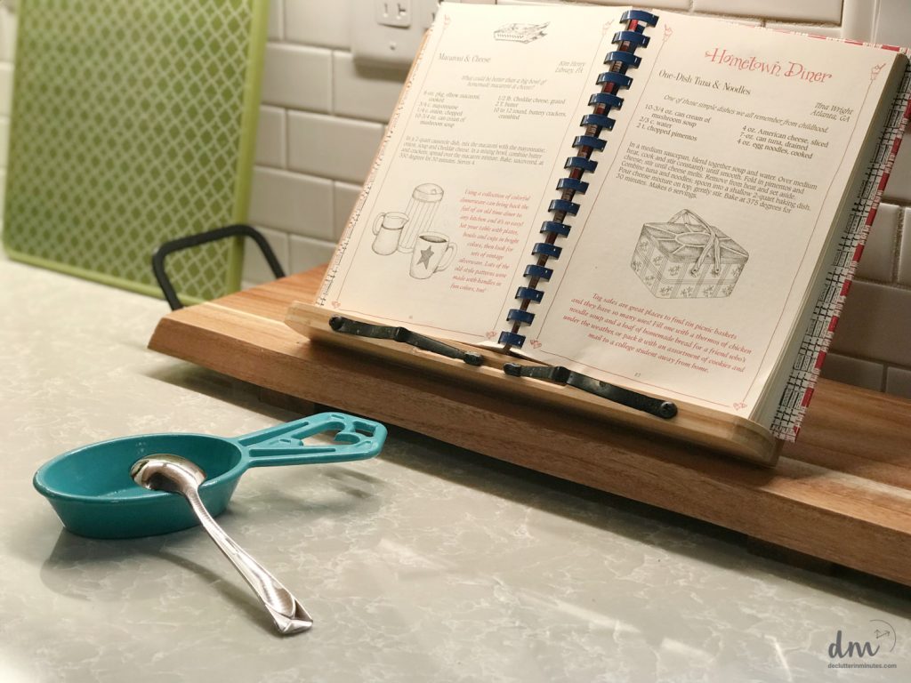 a cookbook opened on a counter nest to a spoon