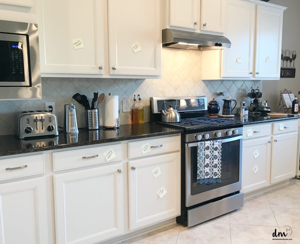 A white kitchen with sticky notes on cabinets 