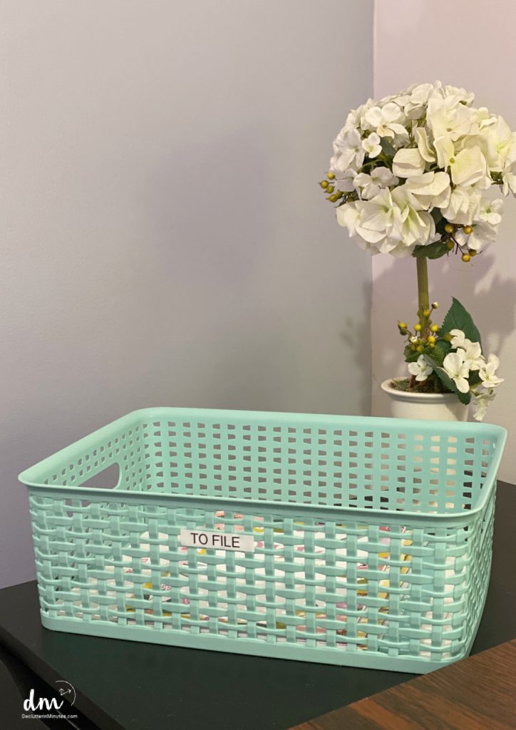 a teal basket on a table with a To File label 