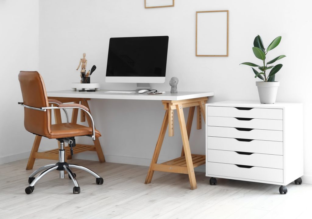 a white desk in a small home office with a white drawer organizer.jpeg
