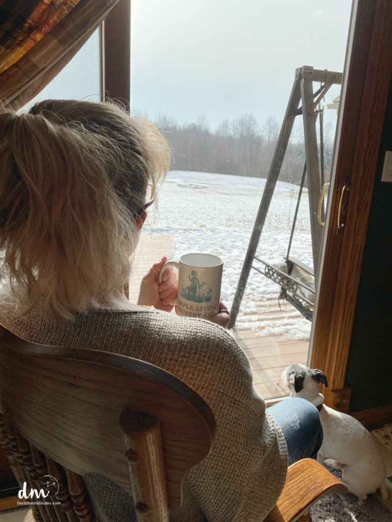 a woman looking out a window onto a snow covered landscape