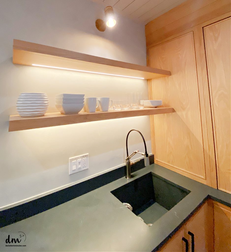 shelves on a wall in a kitchen above a sink