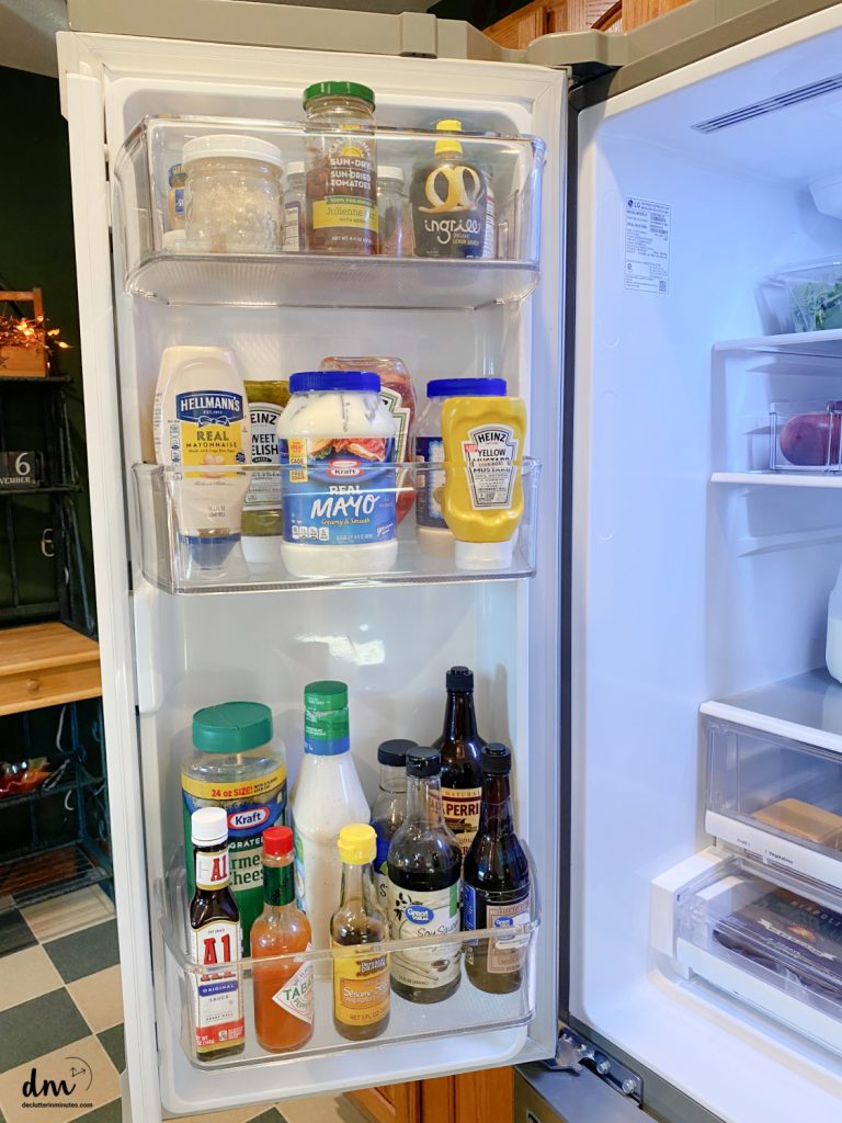 the inside door of a fridge that is clean and organized with condiments