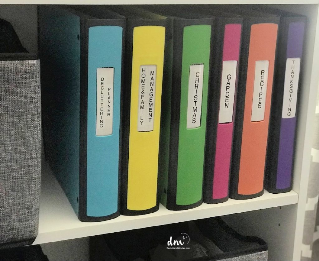 white shelf with colored binders stored on a shelf