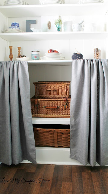 Image that shows wicker boxes on the bottom cabinet shelves.