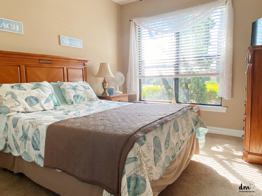 a bed with a blue shell comforter in a brightly lit bedroom