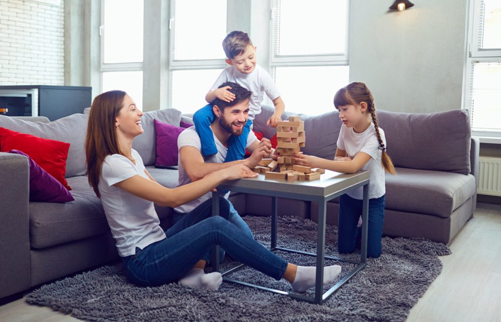 a family playing game at a table near to a couch