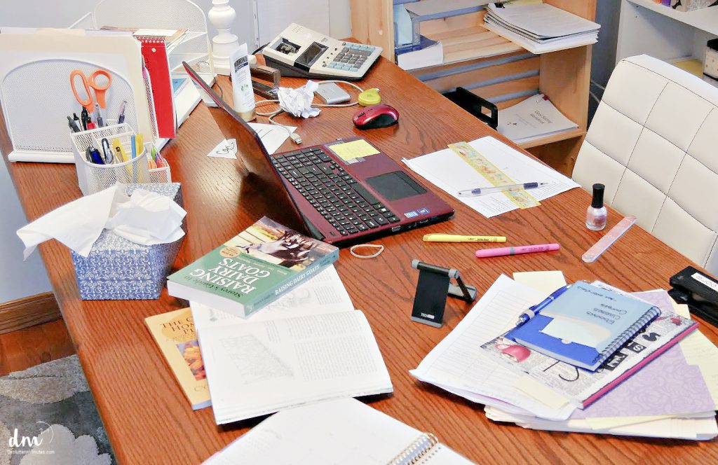 a messy desk full of paper clutter and office supplies