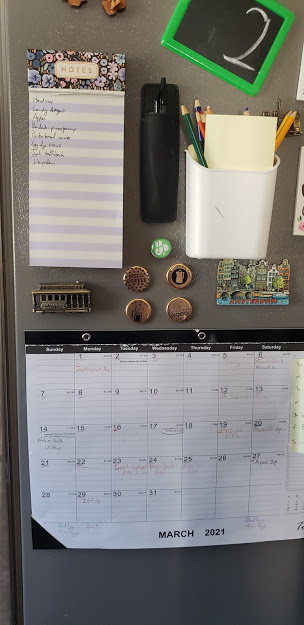 Image that shows a calendar, bins, magnets on the fridge as a command center.