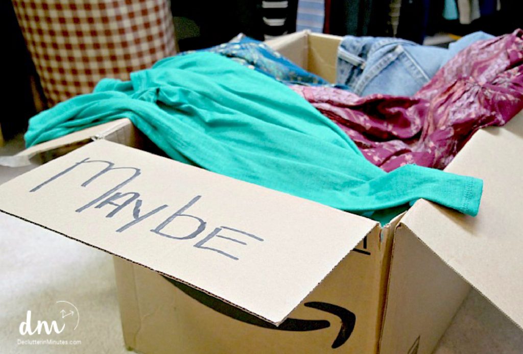 A maybe box that is filled with clothes from a bedroom